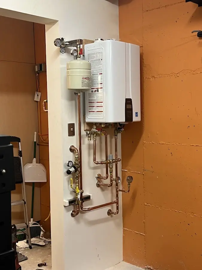 Plumbing technician inspecting water heater connections in Natchitoches